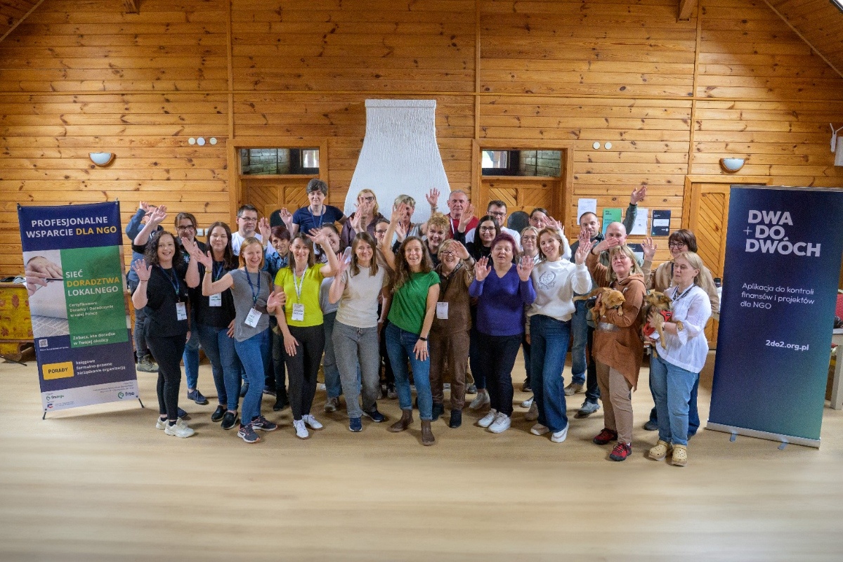 Grupa osób na zdjęciu macha do osoby fotografującej